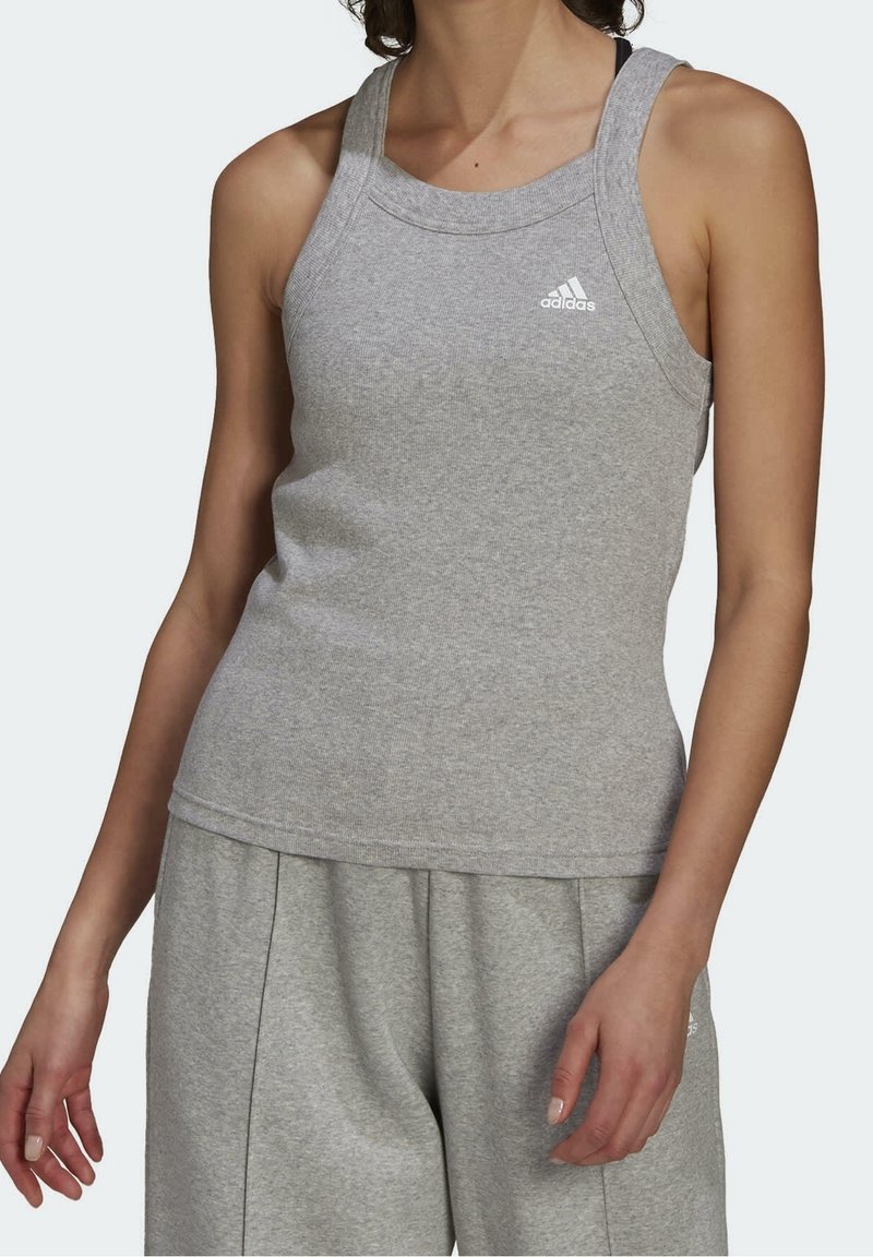 Débardeur athlétique gris en tissu doux avec un col rond et des bretelles épaisses. Présente un petit logo blanc sur la poitrine.