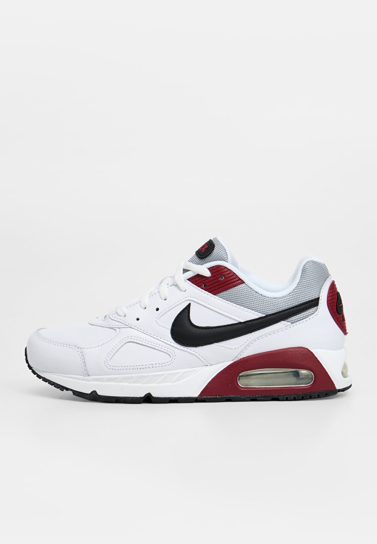 Baskets blanches Nike Air Max avec un swoosh noir, un mesh gris près de la cheville et des accents rouges sur la semelle et le talon.