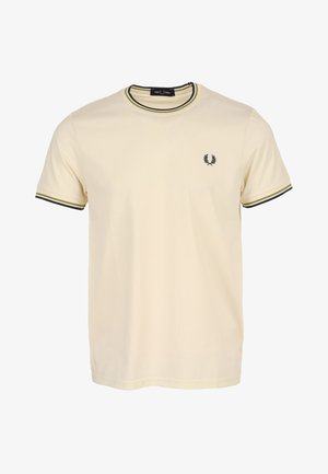 T-shirt en coton crème avec un col rond, bordure rayée contrastante noir et vert olive sur le col et les manches, et petit logo sur la poitrine.