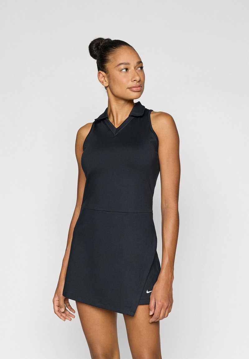 Μαύρο αθλητικό φόρεμα χωρίς μανίκια με γιακά πόλο, εφαρμοστό κορσάζ και φουσκωτή φούστα. Διαθέτει το λογότυπο της Nike στο κάτω μέρος. Λείο ύφασμα.