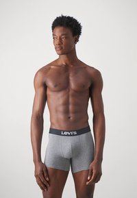 Pelēkas kokvilnas bokseršorti ar melnu jostu, kurā ir redzams Levi's logotips, šaura piegriezuma, mīkstas tekstūras un elpojoša dizaina.