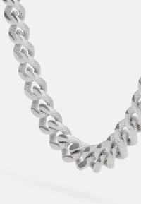 Zilveren ketting met in elkaar vergrendelde schakels, voorzien van een gestructureerd oppervlak en gepolijste accenten, met afwisselend matte en glanzende afwerkingen.