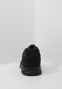 Černé turistické boty s texturovanou svrškem z jemného semiše, síťovinovými detaily a pevnou gumovou podrážkou. Mají zaoblenou špičku a vyztuženou patu.