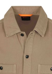 Beige overhemd met kraag, zwarte knopen, borstzak en een oranje label aan de binnenkant. Gemaakt van textuurstof.