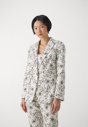 Completo giacca e pantaloni a stampa floreale in beige chiaro con accenti neri e verdi. Presenta una vestibilità sagomata e colletto a punte.