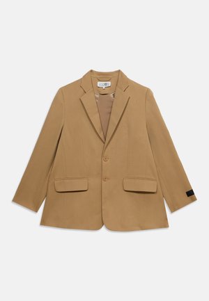 Blazer beige simple boutonnage avec revers crantés, deux boutons, poches à rabat et manches longues, posé à plat sur fond blanc.