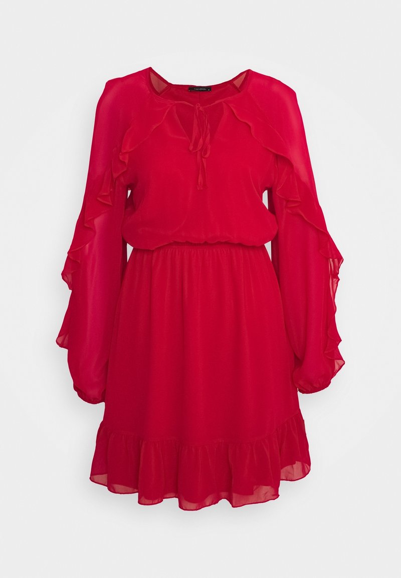 Robe en chiffon rouge avec des manches longues à volants, un col à nouer et une taille froncée. L'ourlet présente un détail à volants superposés.