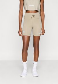Μπεζ αθλητικές σορτς με ψηλή μέση από λείο ύφασμα, με κορδόνι στη μέση, λογότυπα και εφαρμοστή γραμμή.