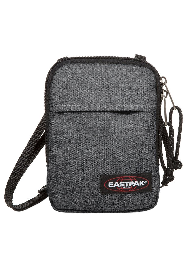Borsa a tracolla grigia in tessuto con chiusura a zip, tasca frontale e patch con logo. Dotata di una tracolla rimovibile e superficie testurizzata.