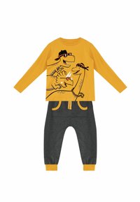 Dino-thema gele lange mouw t-shirt met grafisch ontwerp; grijze broek met gele accenten en zakdetails. Zachte katoenmix stof.