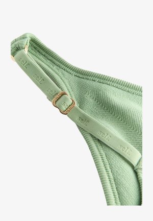 Grüne, strukturierte Bralette mit einem Chevron-Muster, verstellbarem Träger mit eingeprägtem Markennamen und einem Verschluss aus goldfarbenem Metall.