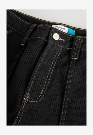 Jeans dritti neri a vita alta in tessuto testurizzato, con cuciture arancioni a contrasto e chiusura con bottone metallico visibile. Etichetta di cura inclusa.