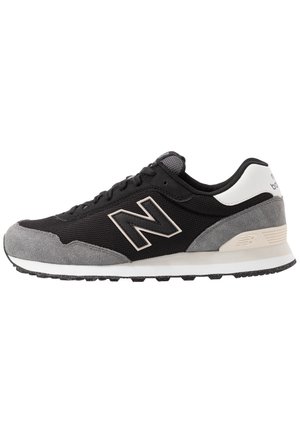 Czarno-szary but sportowy New Balance z białym akcentem na pięcie, cholewką z siateczki i zamszu oraz fakturowaną gumową podeszwą, widok z boku.