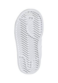 White rubber shoe sole featuring a zigzag pattern, designed for grip, with textured edges and rounded toe for a streamlined shape.