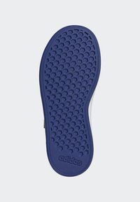 Semelle de chaussure Adidas arborant un motif hexagonal texturé en violet et un bord lisse, avec un logo embossé près du talon.