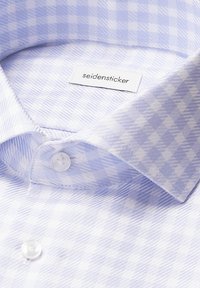 Lichtblauw geruit overhemd van een textiel met structuur. Kenmerkt zich door een zachte kraag, witte knopen en een merklabel in de halslijn.