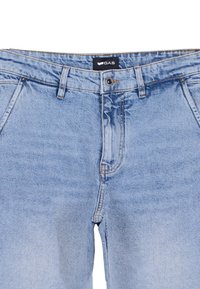 Jeans in denim blu chiaro con un classico design a cinque tasche, zip e passanti per cintura. Il tessuto presenta una leggermente sbiadita.