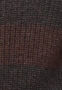 Knit fabric with a textured surface, featuring dark brown and muted rust stripes, showcasing a soft, warm appearance.