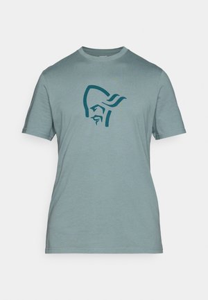 T-shirt à manches courtes, bleu pâle, en tissu doux, avec un graphique bleu foncé représentant la tête stylisée d'une figure sur le devant.