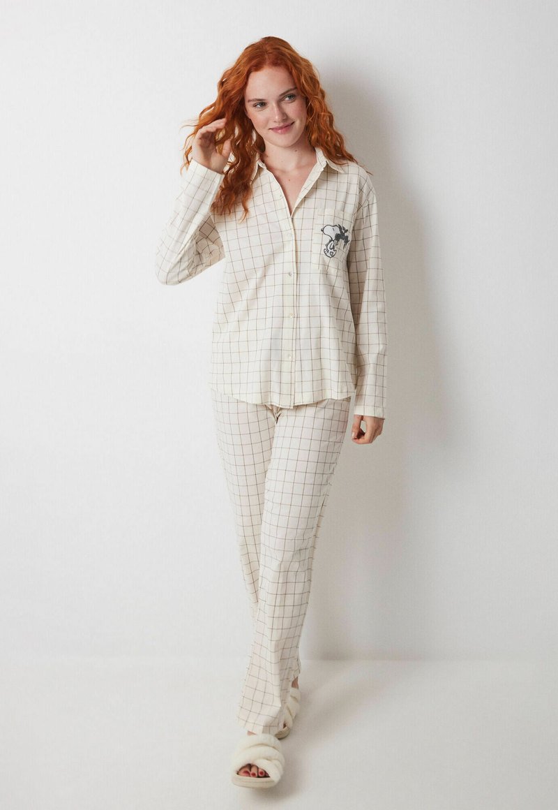Cremfarbener Pyjama-Set mit Karomuster. Langärmliges Shirt mit einer Tasche und einem gestickten Design. Weicher, leichter Stoff.