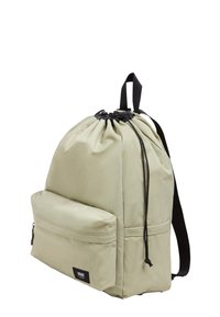 Sac à dos à cordon en tissu vert clair, avec une poche zippée à l'avant, des bretelles réglables noires et une fermeture sur le dessus froncée.