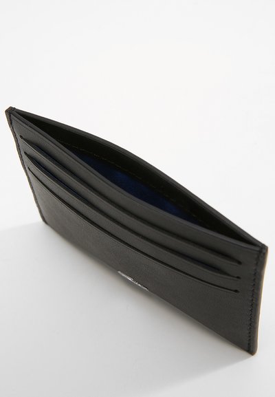 Portefeuille en cuir noir avec plusieurs emplacements pour cartes, une texture lisse et un intérieur bleu. Présente un logo de marque discret sur le devant.