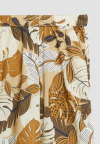 Pantaloni larghi con elastico in vita con motivo di foglie tropicali marroni, beige e bianche e fantasia a macchie.