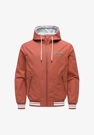 Veste à capuche couleur rouille avec cordons blancs, fermeture éclair avant, poches zippées, poignets côtelés et logo "ragwear" sur la poitrine.