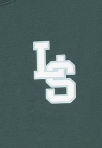 Tmavě zelená mikina se širokým bílým grafikou, na které jsou písmena "L" a "S" v tučném obrysu. Hladká bavlněná textura.