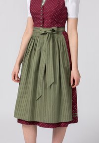 Traditional dress featuring a burgundy bodice with white floral patterns, and a green pleated skirt with striped accents and a tied belt.