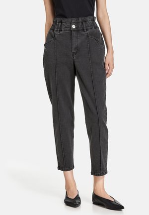 Pantalons en denim noir taille haute avec une coupe décontractée, jambes fuselées, poches avant et fermeture à bouton. Texture lisse et coutures contrastées.