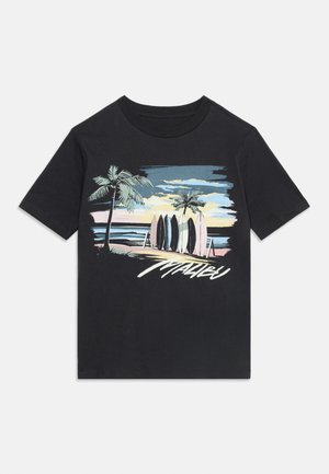 Camiseta negra con gráfico de palmeras, tablas de surf en la playa al atardecer y texto "Malibu" en una tipografía estilizada debajo de la escena.