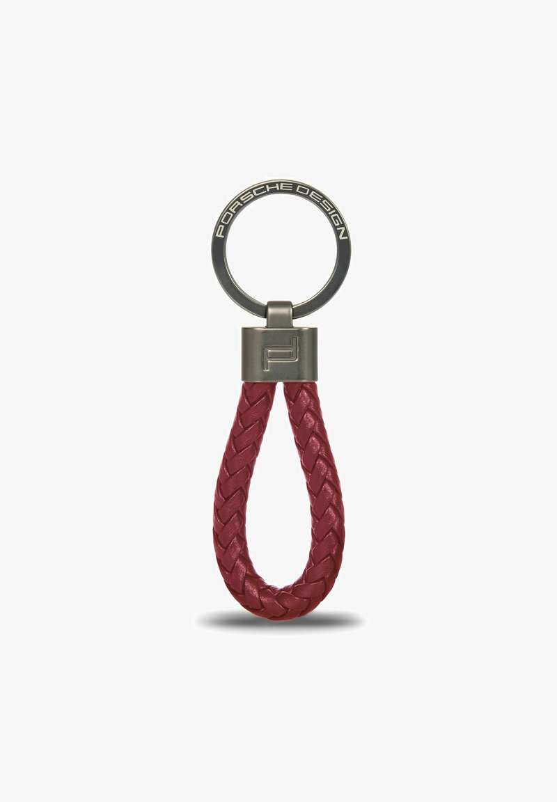 Portachiavi Porsche Design con un cinturino in pelle intrecciata rossa e un anello circolare grigio metallico con marchio inciso.