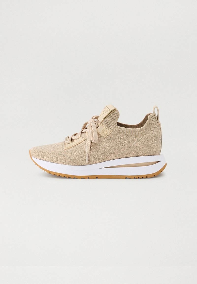 Beige knitted low-cut sneaker with lace-up front, white cushioned sole, and brown rubber outsole, shown from side on a plain background.