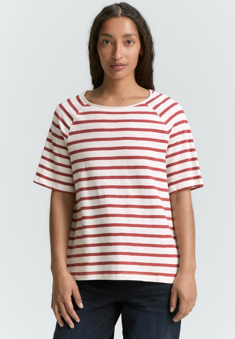 Cremefarvet t-shirt med røde vandrette striber, med en bred halsudskæring og korte ærmer. Casual, afslappet pasform med blød tekstur.