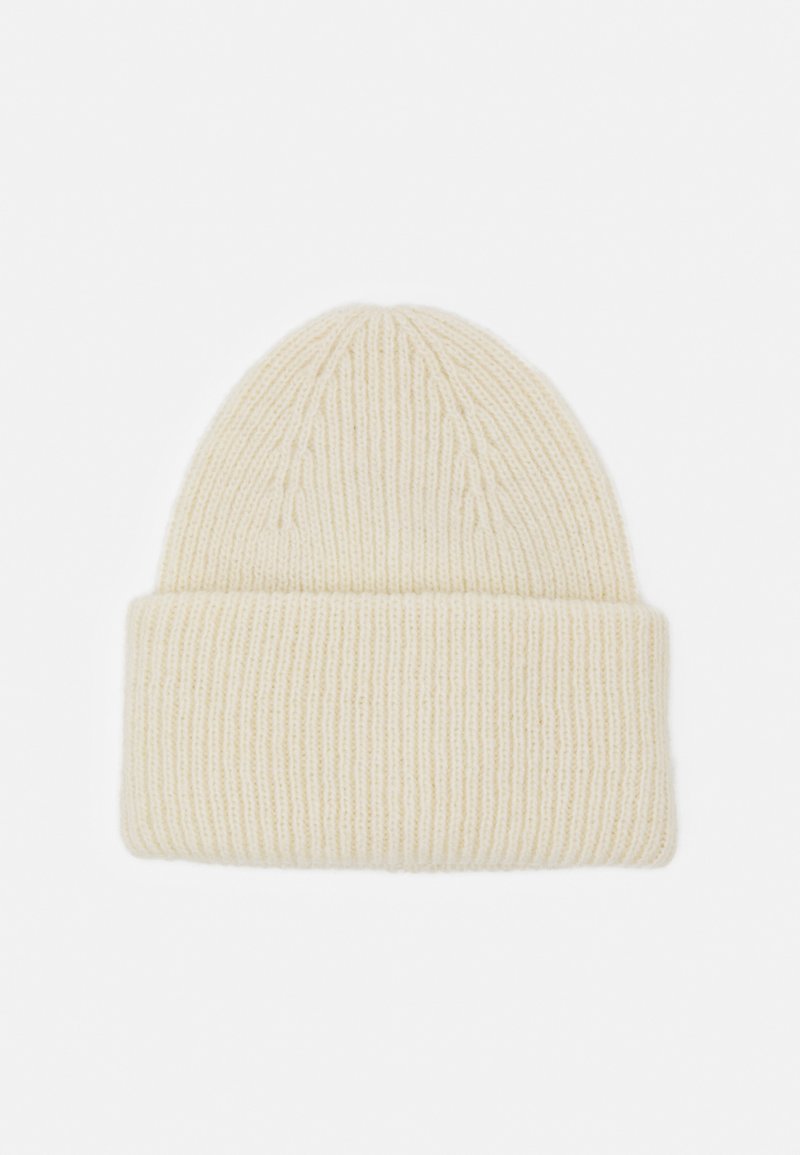 Knit beanie in soft cream wool, featuring a ribbed texture, rounded top, and a folded cuff for added warmth.