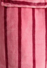 Miękki różowy ręcznik z pionowymi ciemnoróżowymi paskami, złożony na górze, ukazujący puszystą teksturę i żywe kolory.