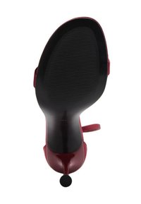 Scarpa con tacco alto rossa, con una finitura liscia e lucida, design aperto nella parte anteriore, cinturino alla caviglia e suola nera texturizzata. Presenta un tacco a punta.
