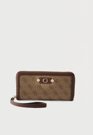 Portefeuille bracelet marron Guess avec motif logo répété et plaque "G" dorée à l'avant, fermeture éclair et sangle détachable.