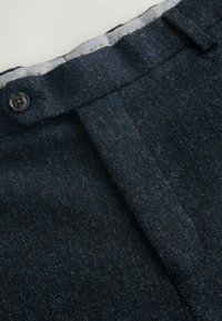 Spodnie z mieszanki wełny w ciemnoniebieskim kolorze o wykończeniu z teksturą, z zapięciem na guzik i plisą z przodu dla eleganckiego wyglądu.