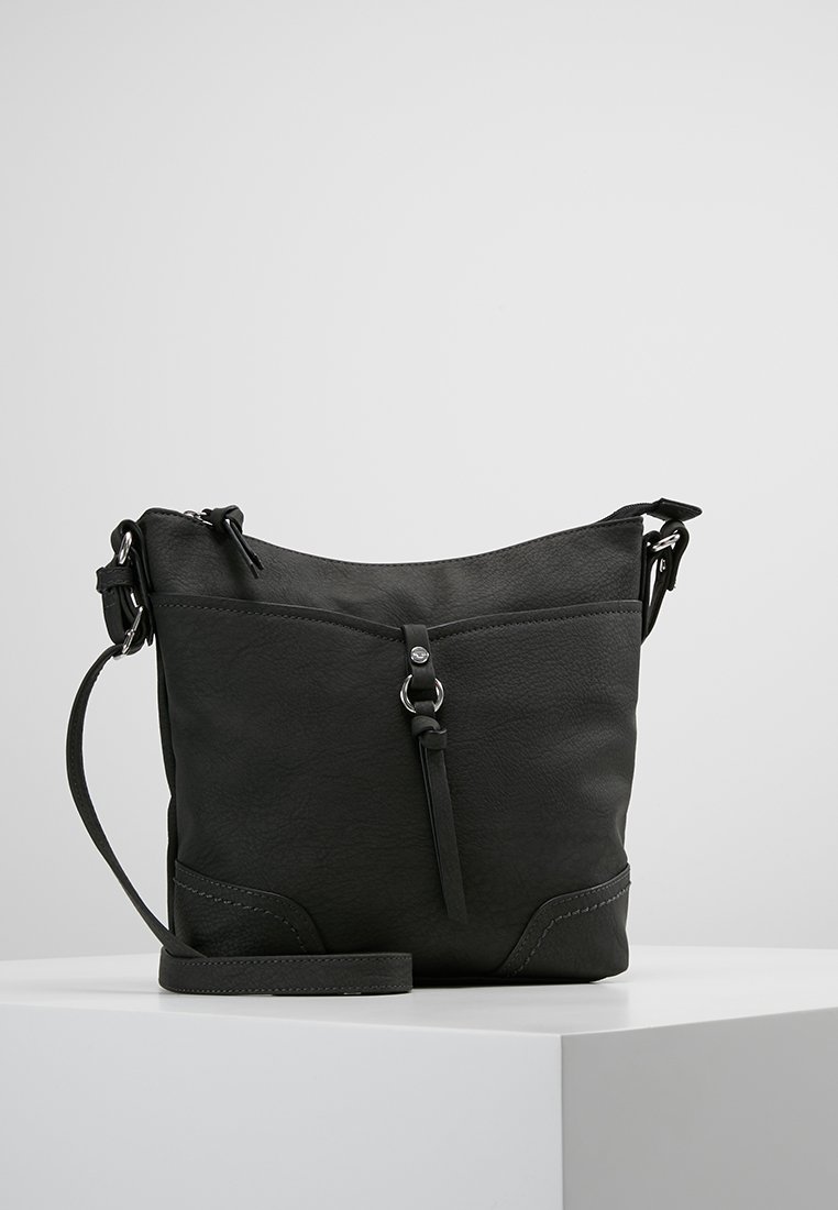 Sac en cuir noir à bandoulière avec fermeture éclair, sommet incurvé, surface texturée et sangle ajustable. Détail distinctif : un élément métallique central.