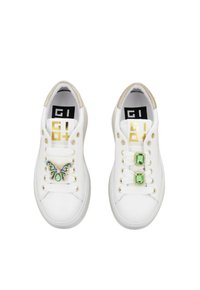 Sneakers bianchi con una finitura liscia, dotati di un decorazione a forma di farfalla su una scarpa e di accenti in pietre verdi sull'altra. Dettagli beige sul tallone.