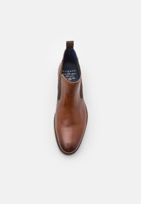 Bruine leren chelsea boot met elastische zijpanelen, ronde neus en contrasterende blauwe binnenkant. Voorzien van een aantreklip aan de achterkant.