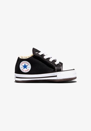 Čierna nízka teniska Converse All Star s bielymi šnúrkami, gumovou podrážkou a okrúhlou nášivkou s logom na boku, zobrazená na bielom pozadí.