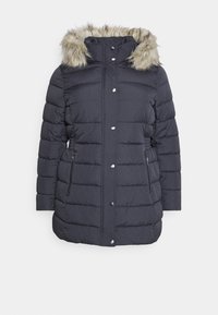 Giacca imbottita di un blu scuro con cappuccio in ecopelliccia, caratterizzata da pannelli cuciti, tasche laterali con zip e bottoni a pressione metallici.