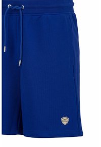 Blaue Baumwollshorts mit elastischem Bund und Kordelzug. Mit seitlichen Taschen und einem kleinen Emblem am unteren Bein.