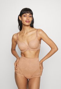 Conjunto de lencería marrón claro que incluye un sujetador acolchado con tirantes ajustables y unas braguitas de cintura alta con una sutil textura de patrón floral.