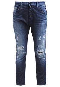 Mørkeblå slidte jeans med flere revner og frynsete detaljer, med knaplukning foran og klassiske lommer.