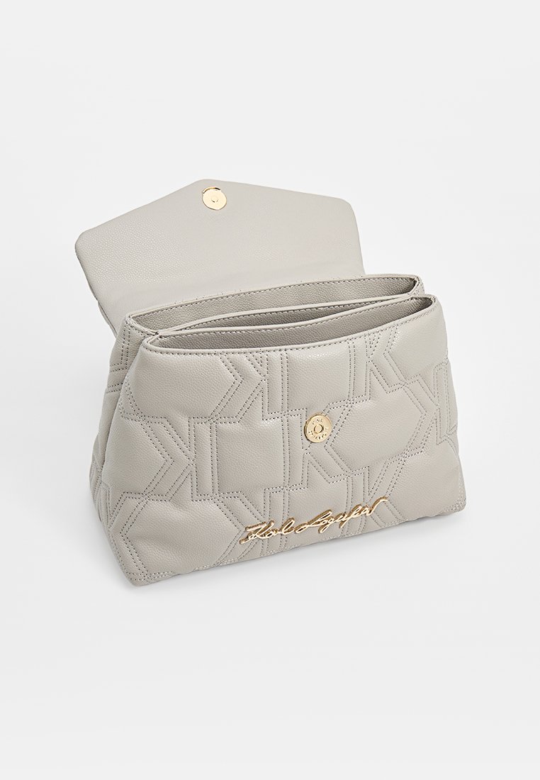Hellgraue Leder-Clutch mit geometrischer Stickerei, goldenem Druckknopfverschluss und geschwungenem goldenen Logo auf der Vorderseite, offen gezeigt mit sichtbaren Innenfächern.