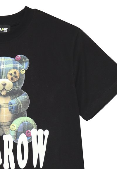 T-shirt di cotone nero con una grafica di un orso a quadri colorato e dettagli con bottoni, e lettere bianche in grassetto che spellano "BROW". Maniche corte incluse.